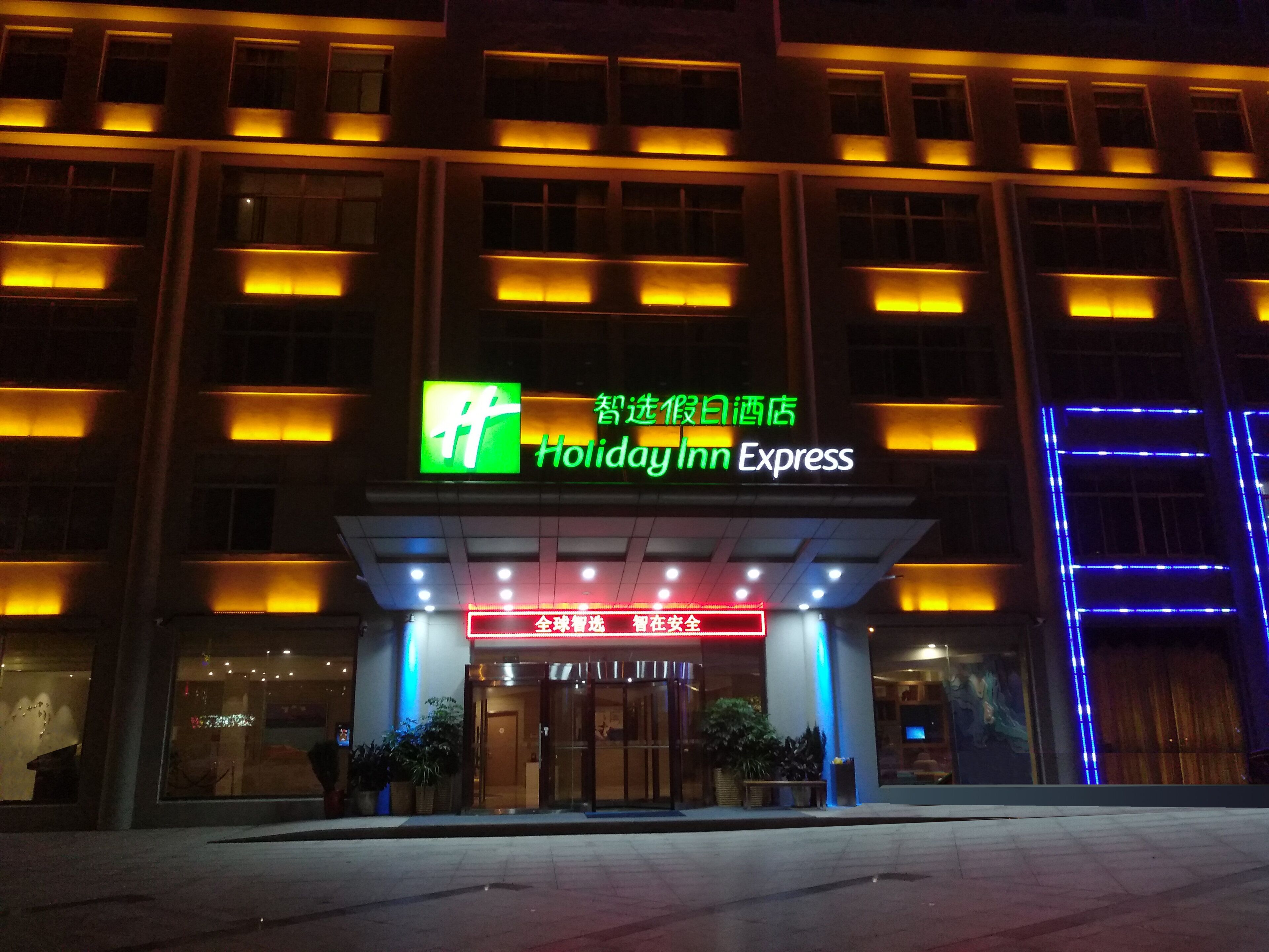 A Holiday Inn Express hotel entrance with illuminated signage and a modern facade.