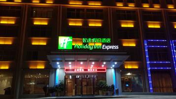 A Holiday Inn Express hotel entrance with illuminated signage and a modern facade.