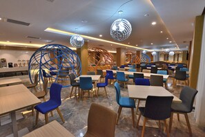 A modern dining area with multiple tables and chairs, decorative spherical light fixtures, and a clean, contemporary design. - Holiday Inn Express-Weihai Economic Zone by IHG (Weihai)