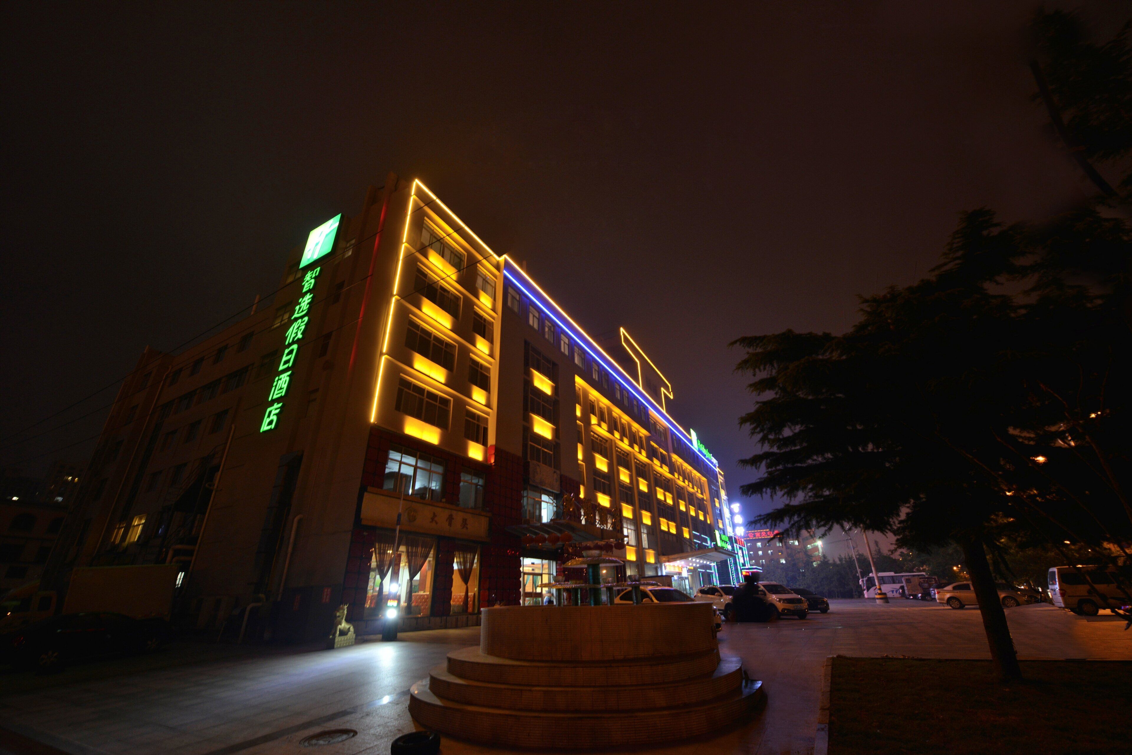 A multi-story hotel with illuminated signage and a prominent entrance.