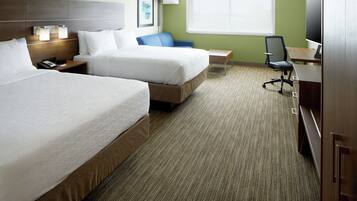 Quarto de hotel com duas camas, uma escrivaninha, uma cadeira e uma televisão.