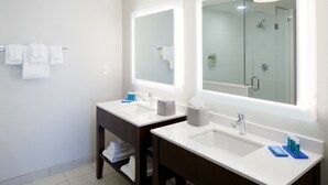 A modern bathroom with two sinks, a large mirror, and a glass-enclosed shower. - Holiday Inn Express & Suites-Cincinnati North - Liberty Way by IHG (West Chester)