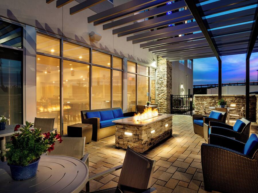 Un área de patio al aire libre con asientos, una chimenea y vistas al cielo.