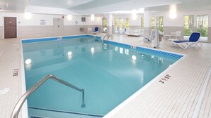 A swimming pool with a lifeguard on duty, a changing room, and a sunbed area.