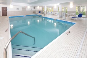 Una piscina techada, sillones reclinables de piscina