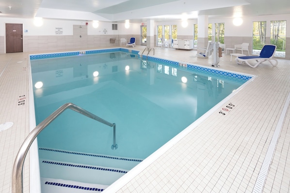 Una piscina con socorrista de guardia, vestuario y zona de hamacas.