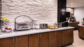 A breakfast buffet setup with various food items and a toaster.