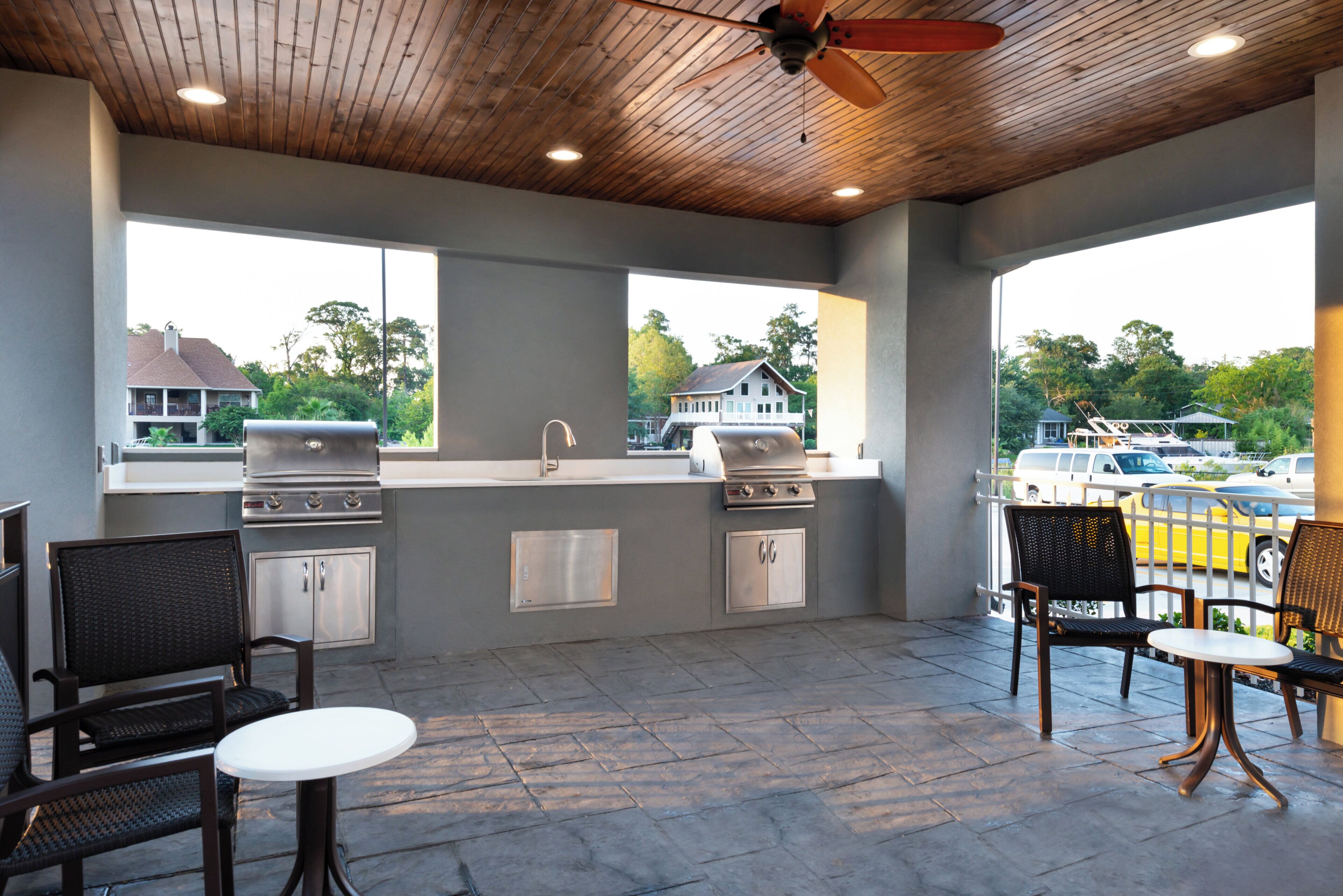 An outdoor patio with a grill, seating, and a view of the surrounding area.