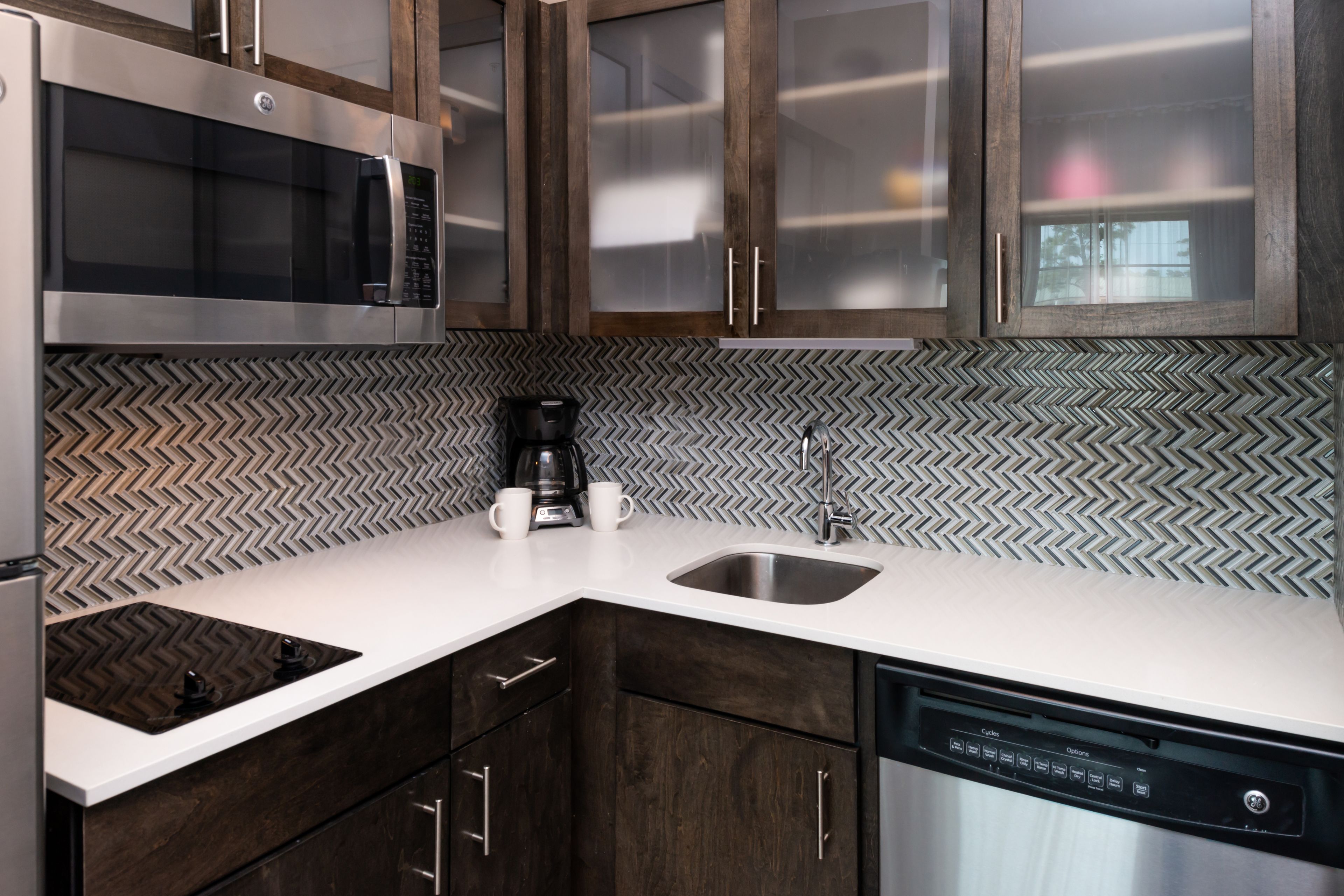 A modern kitchen with a microwave, coffee maker, and dishwasher.