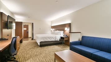 Una camera d'albergo con un letto, una scrivania, una sedia, un divano e una televisione.