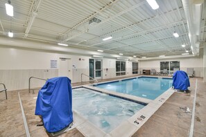 An indoor swimming pool with clear water, tiled edges, and a covered area with a lifeguard chair. - Holiday Inn Express and Suites-Lehi - Thanksgiving Point by IHG (Lehi)