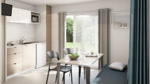 Une cuisine moderne équipée d’un four à micro-ondes, d’une table à manger avec des chaises et d’un canapé avec un coussin.