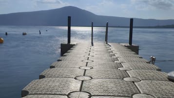 A pier leading to a body of water with a mountain in the background.