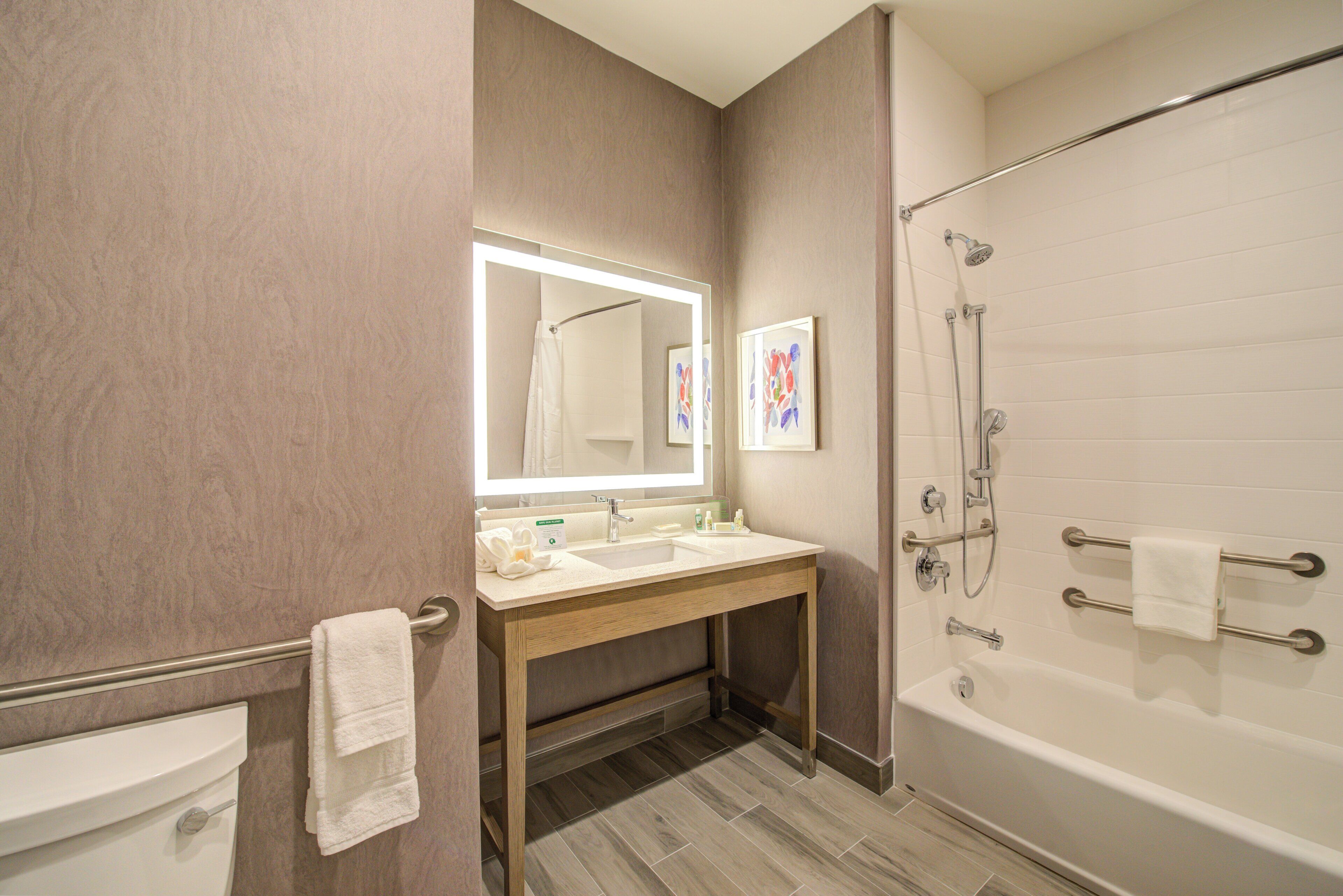 A bathroom with a sink, mirror, and shower.