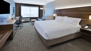 A hotel room with a large bed, a desk with a computer, a chair, and a TV. - Holiday Inn Express & Suites Okemos - University Area by IHG (Okemos)