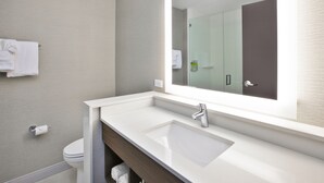 A modern bathroom with a white sink, a large mirror, and a towel hanging on the wall. - Holiday Inn Express & Suites Okemos - University Area by IHG (Okemos)