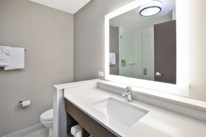 A modern bathroom with a white sink, a large mirror, and a towel hanging on the wall. - Holiday Inn Express & Suites Okemos - University Area by IHG (Okemos)