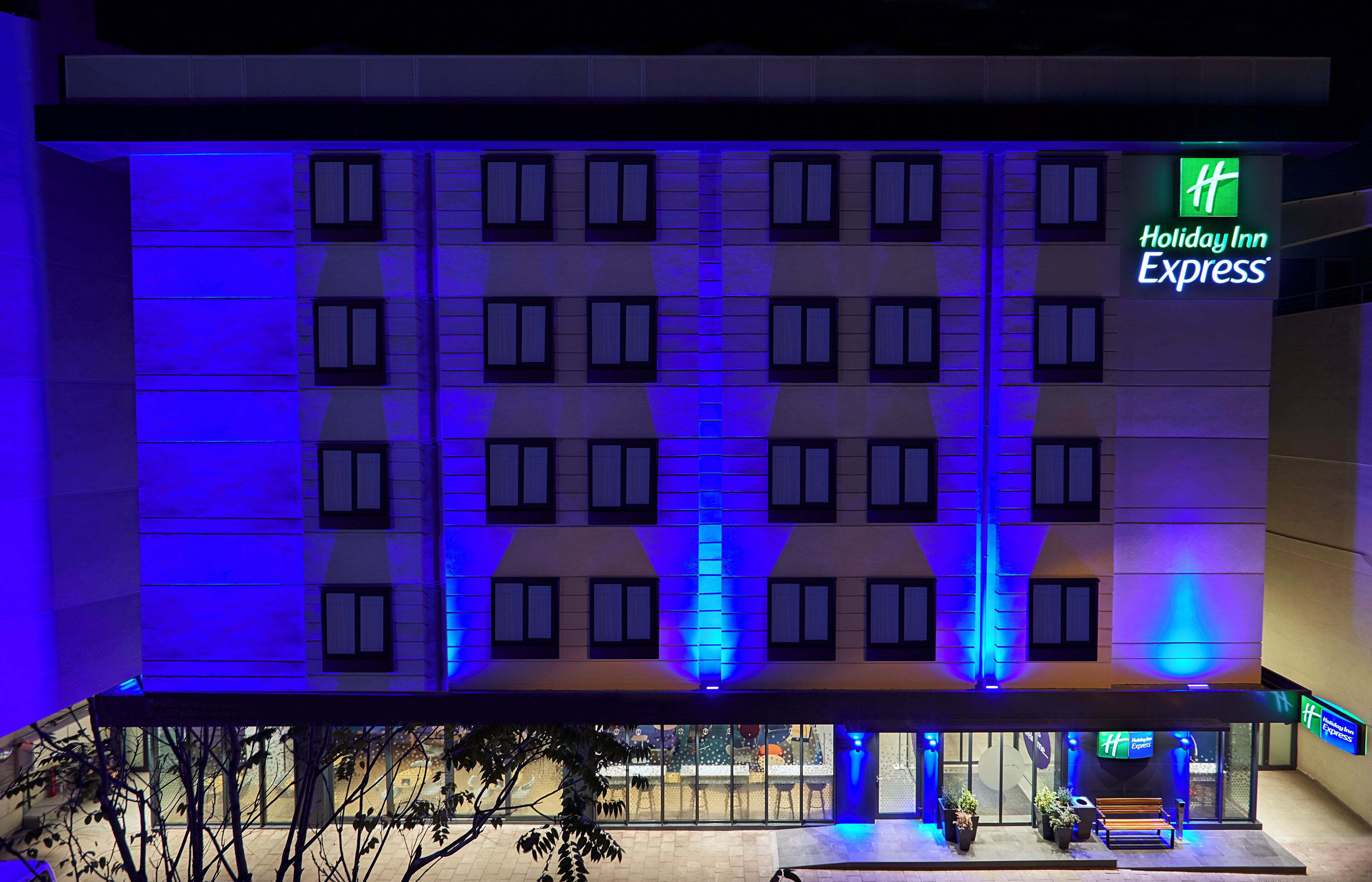 A Holiday Inn Express hotel facade with a symmetrical window pattern and a prominent green logo.