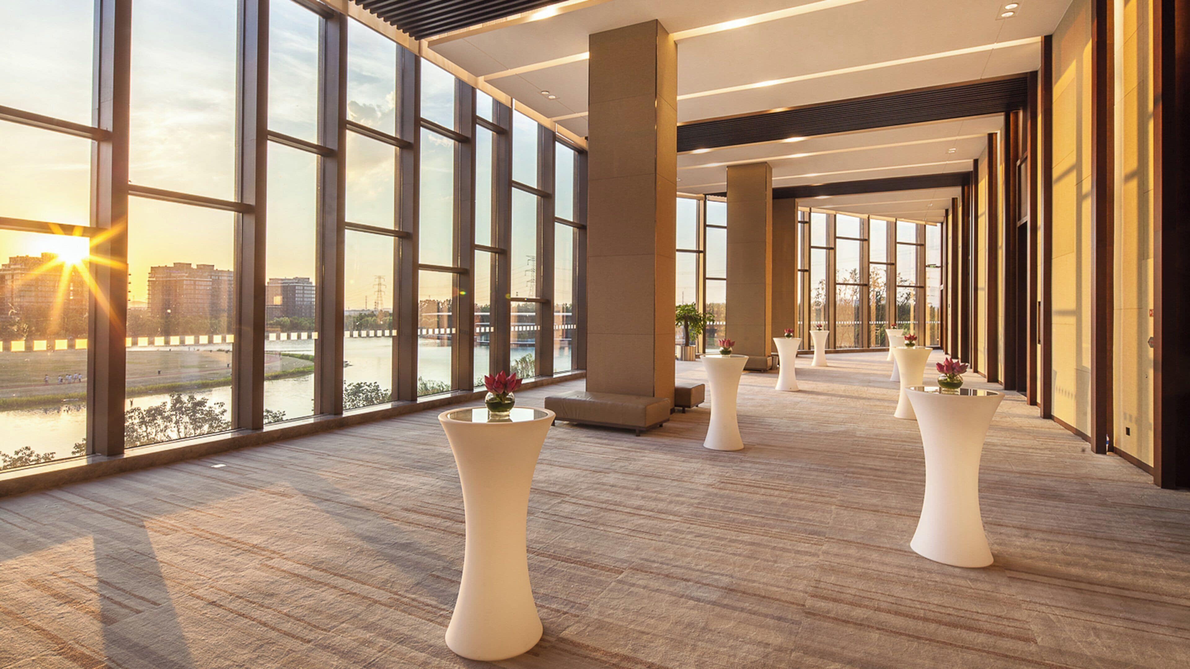 A spacious corridor with large windows, a modern interior design, and a view of a river.