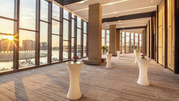 A spacious corridor with large windows, a modern interior design, and a view of a river.
