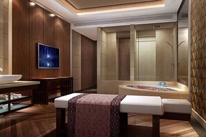 Un baño moderno con una bañera grande, un tocador con espejo y un televisor montado en la pared.