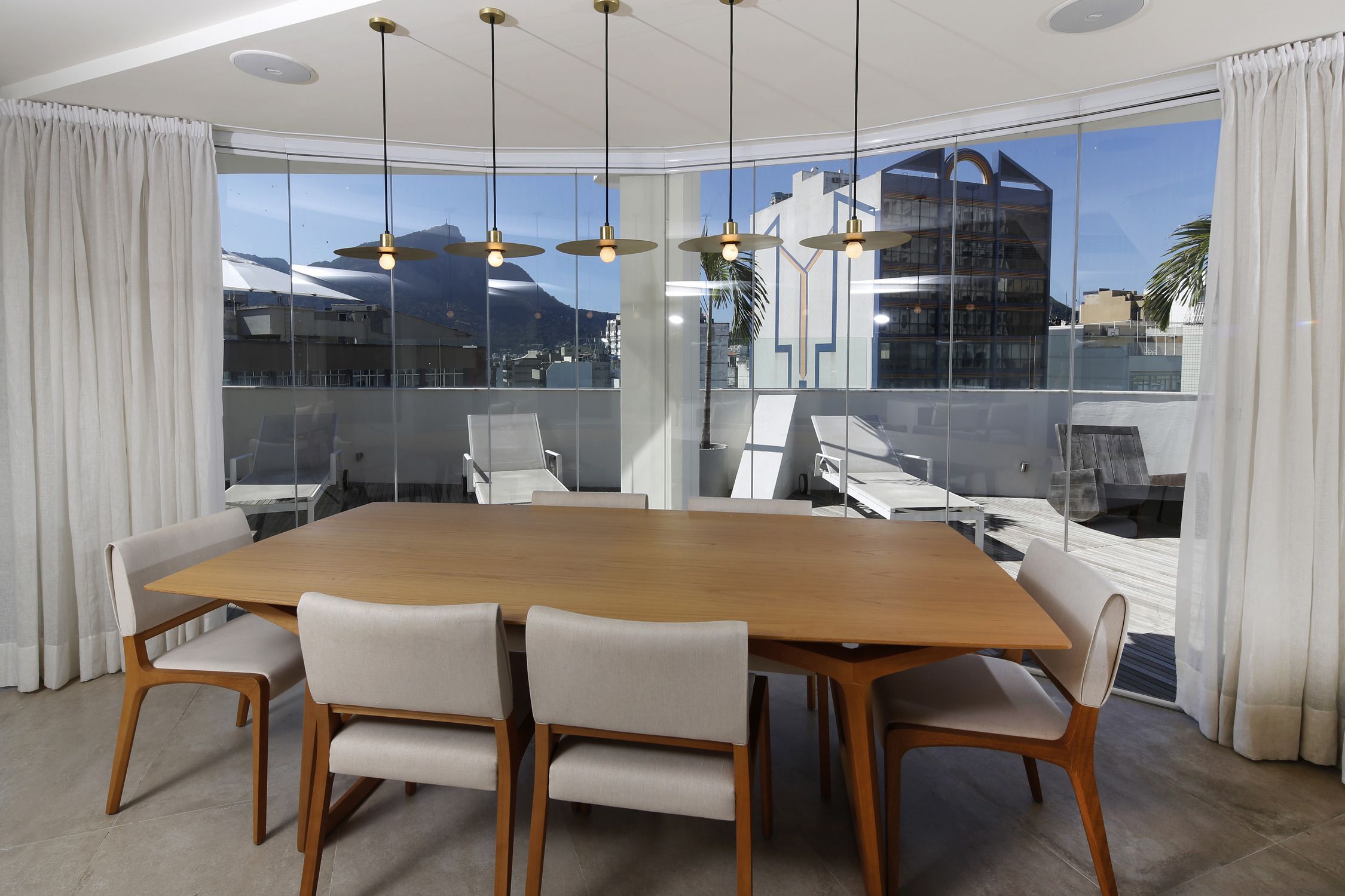 Ein moderner Konferenzraum mit einem großen Holztisch, sechs Stühlen und einem großen Fenster mit Blick auf die Stadt.