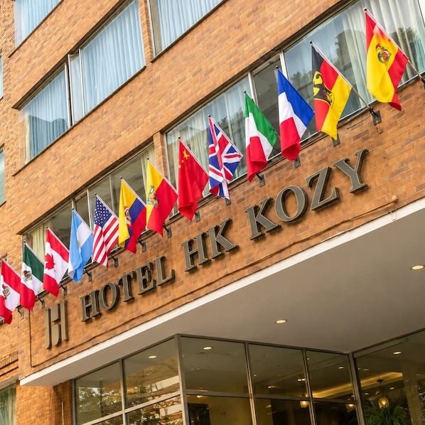 A hotel building with multiple national flags displayed outside.