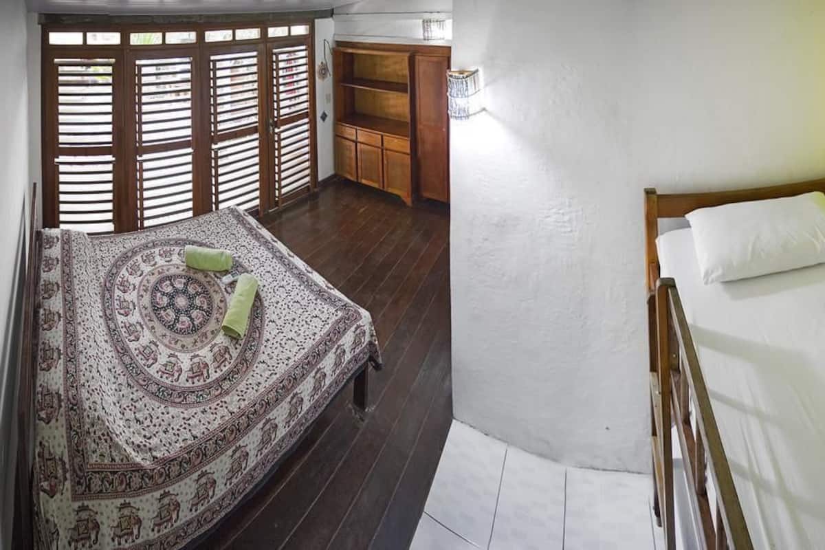 A room with a bed, a wooden cabinet, and a patterned rug.
