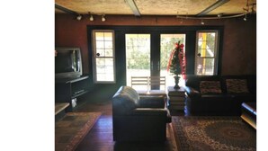A living room with a sofa, a television, and a Christmas tree. - 3 Bed Blue Mountain Cottage with Hot Tub (The Blue Mountains)
