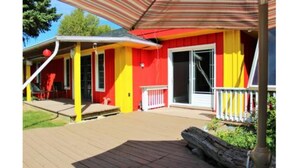 A deck with a red and yellow building in the background. - 3 Bed Blue Mountain Cottage with Hot Tub (The Blue Mountains)