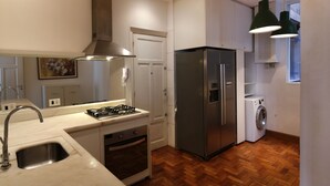A modern kitchen with a stainless steel refrigerator, built-in oven, and a gas stove. - Rio107 - Apartment Copacabana 2 Bedrooms (Rio de Janeiro)