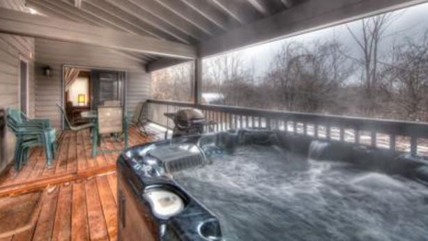 A hot tub on a wooden deck with a view of trees. - 6 Bed Blue Mountain Executive Chalet with Hot Tub 157 (The Blue Mountains)
