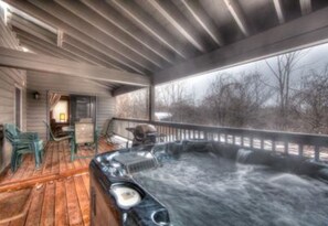 A hot tub on a wooden deck with a view of trees. - 6 Bed Blue Mountain Executive Chalet with Hot Tub 157 (The Blue Mountains)