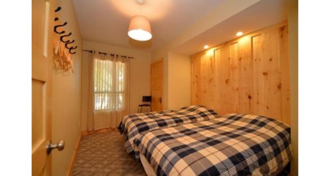 A room with two beds, a wooden wardrobe, a small desk, and a window with curtains. - 9 Bed Blue Mountain Luxury Chalet (The Blue Mountains)