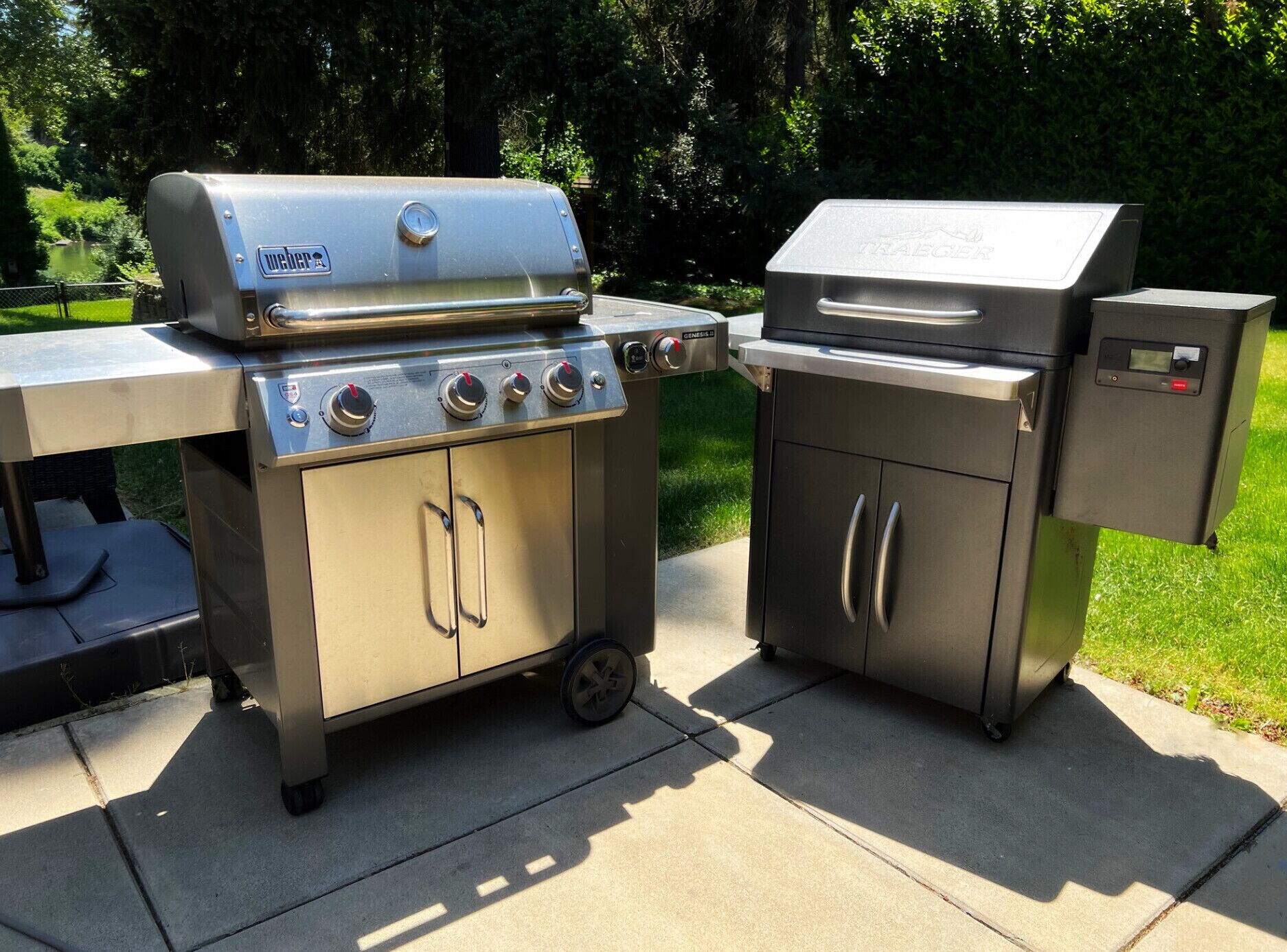 Una parrilla portátil de acero inoxidable con pantalla digital y múltiples quemadores, un gabinete lateral con lavamanos y un compartimento de almacenamiento.