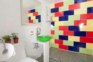 A bathroom with a white sink, green basin, and a tiled wall with multicolored tiles. - Jeonjuhanokvillage guesthouse (Jeonju)