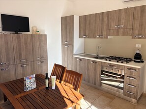 A modern kitchen with wooden cabinets, a built-in oven, a gas stove, and a sink.