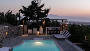 Alberca al aire libre y camastros