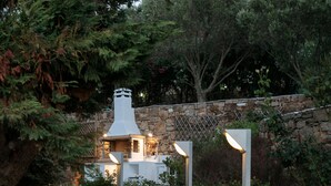 A stone staircase leading to a building with a chimney, surrounded by greenery and stone walls. - Spacious, private luxury villa with pool, & stunning sea and sunset views (Glinado)