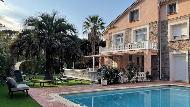 A poolside area with a pool, outdoor seating, and a two-story building with a balcony. - Pool + 10 min walk to the beach (Saint-Raphaël)