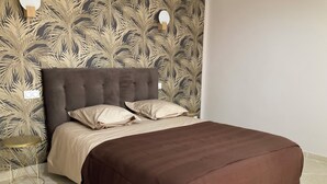 A bed with a brown cover, a grey upholstered headboard, and two white pillows. - Pool + 10 min walk to the beach (Saint-Raphaël)