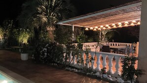 An outdoor patio area with a pool, surrounded by plants and a white railing. - Pool + 10 min walk to the beach (Saint-Raphaël)