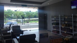 A spacious interior with a seating area, a counter with a sign, and shelves stocked with products. - Ayer Hitam Hotel (Ayer Hitam)