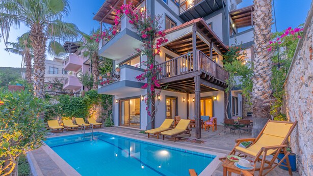 Un edificio de varios pisos con piscina, mobiliario exterior y balcones.