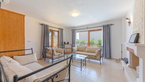 Una habitación con cama, sofá, mesa de centro y chimenea.