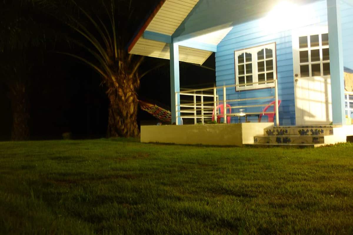 Een laag, eenlaags gebouw met een blauwe gevel en een overdekte veranda.