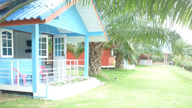 A blue house with a porch and pink chairs. - Maneemudjalin Resorts Farm Stay (Sam Roi Yot)