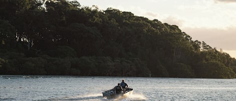 A jet ski on a calm lake with a forested shoreline in the background.