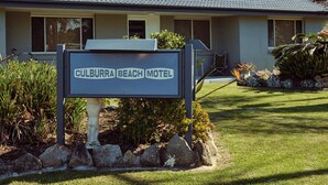 Un motel con un letrero que dice 'Culburra Beach Motel' y techo de tejas.