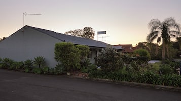 Un motel con un diseño sencillo y moderno, que presenta un techo plano y una antena destacada.